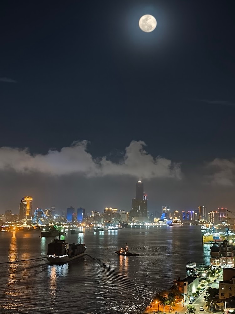 夜晚月亮下的高雄港城市燈火與船隻