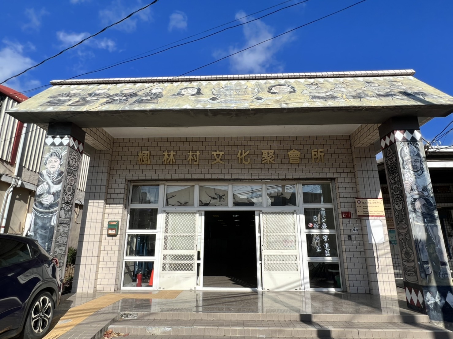 楓林村文化聚會所正面，柱上排灣族彩繪圖騰，藍天白雲，屏東獅子鄉原住民文化