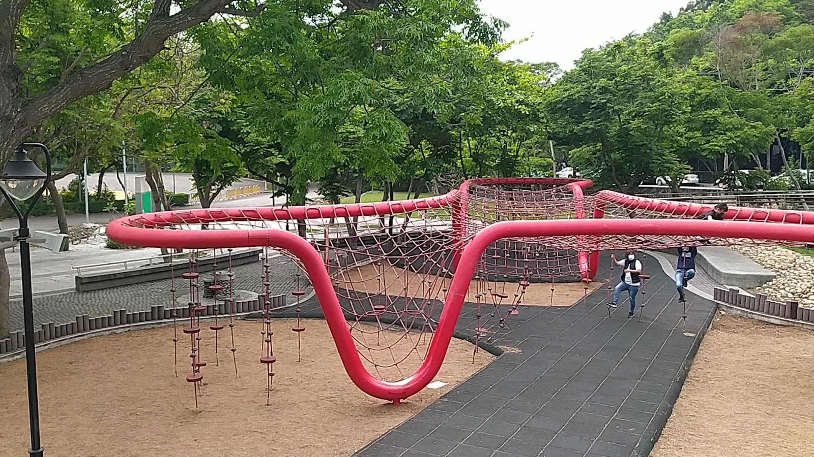 台中鰲峰山運動公園紅色攀爬繩網側面角度，翠綠樹木環繞，環境清幽