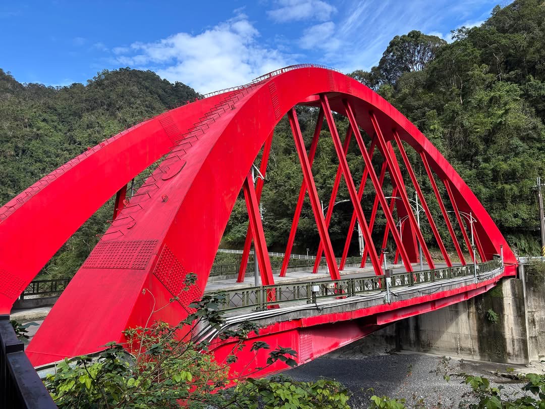 鮮紅色拱形鋼橋橫跨溪流