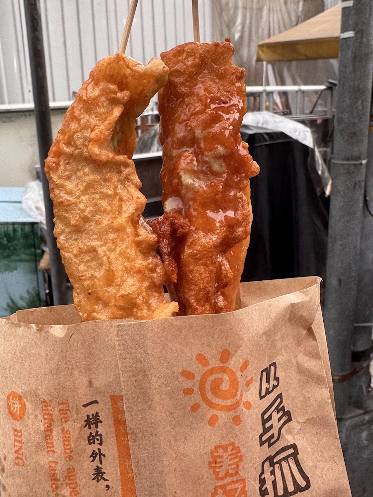紙袋裝著兩支炸旗魚甜不辣串，呈現銅板美食特色