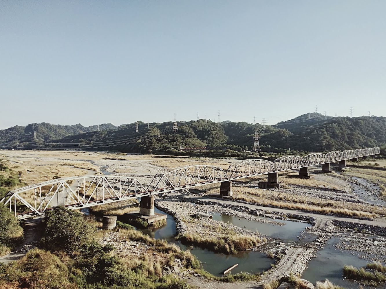 長長鐵橋跨越河流草原與山景