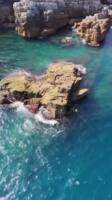 龍洞灣岬清澈海水與岸邊岩石近景