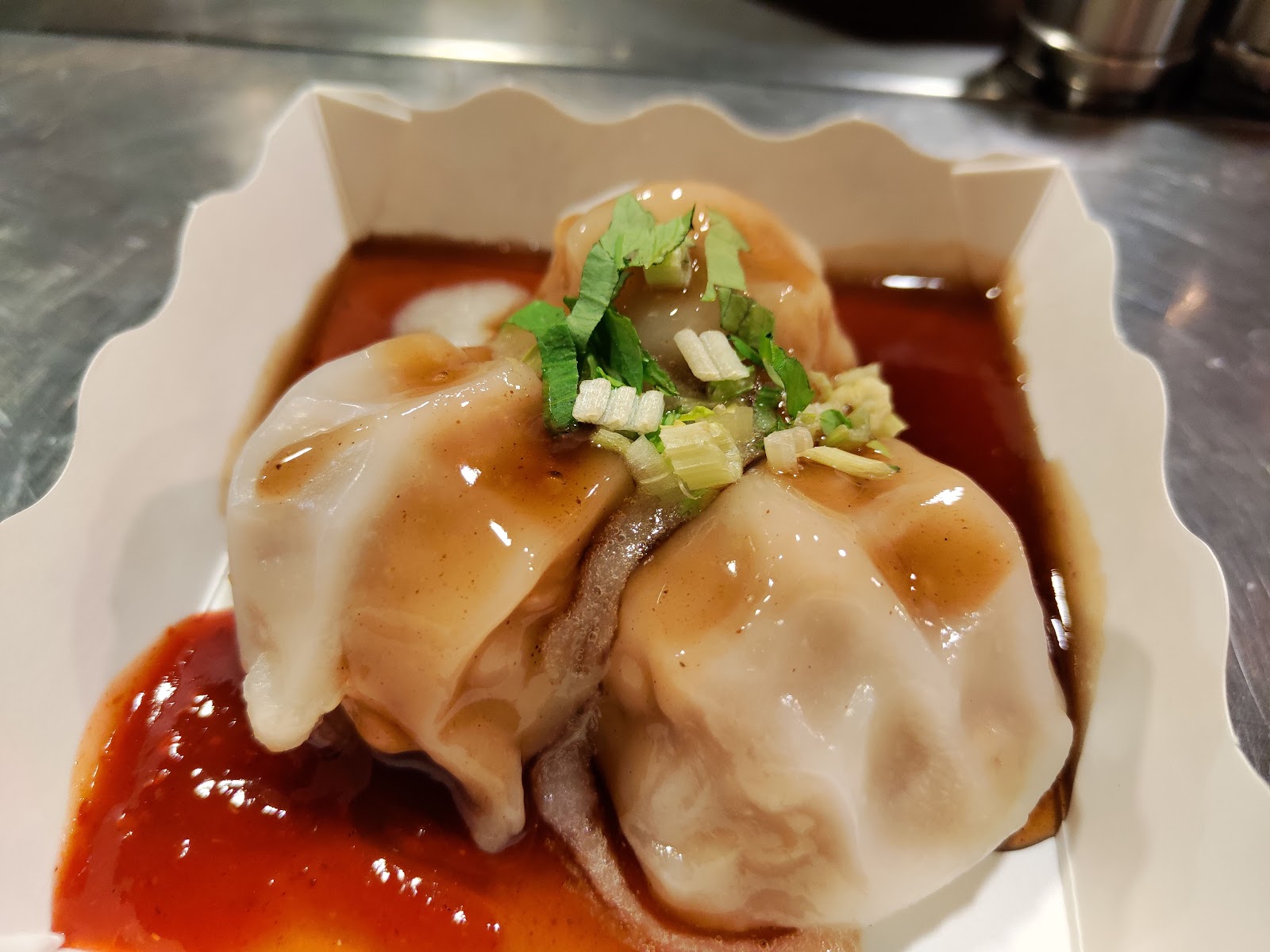 豐原肉丸白盤特寫,兩顆肉丸淋上醬汁撒蔥花,色澤誘人