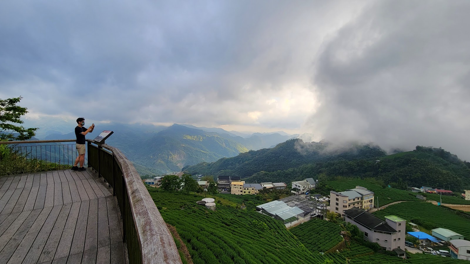 石棹觀景臺木製觀景平台,遊客俯瞰嘉義茶田山城村落
