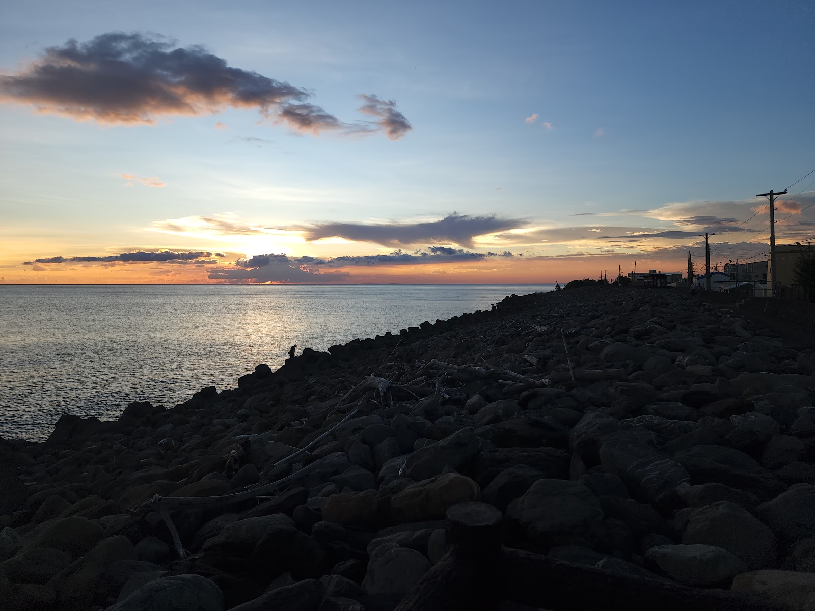楓港海堤散步道黃昏夕陽，礫石海堤延伸，橘紅暮色，屏東枋山楓港景點