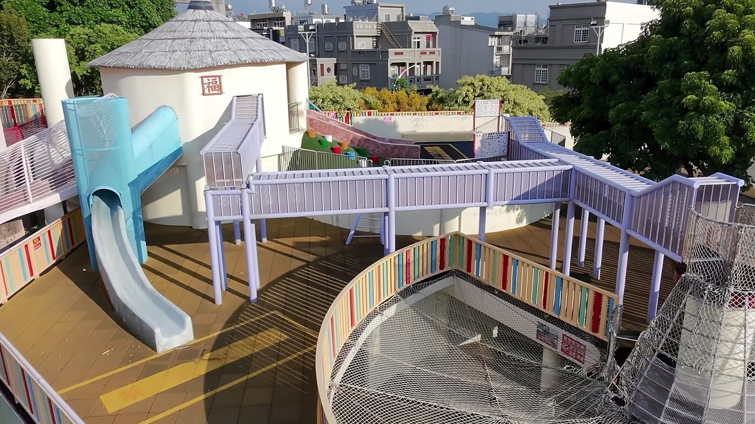 高架空中步道與藍色溜滑梯的親子公園設施。