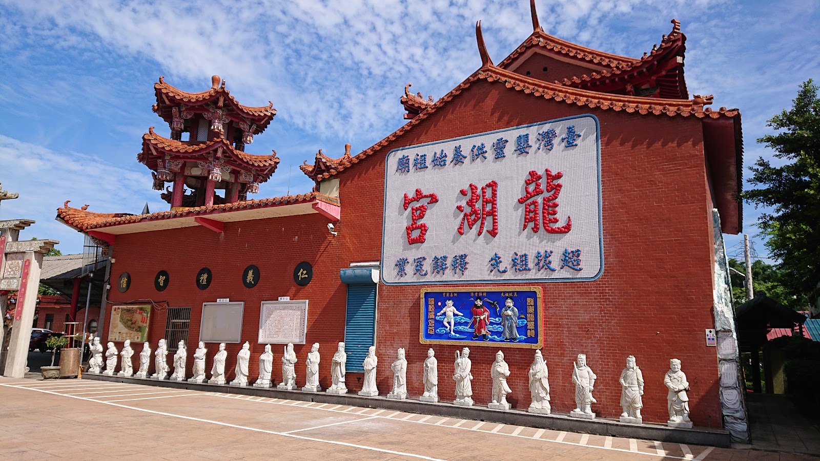 龍湖宮正面全景，石雕神像與彩繪廟門清晰可見