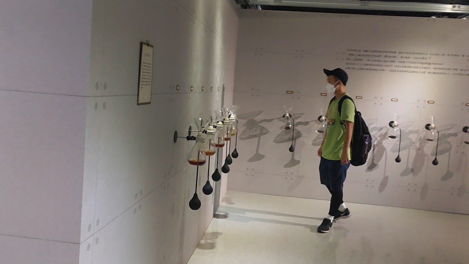 坪林茶業博物館室內展廳,遊客觀看牆上懸掛玻璃器具展示,茶業科技展示