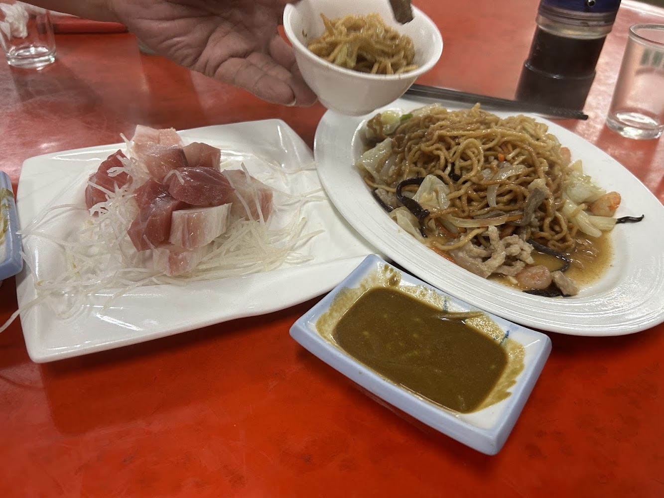 炒麵與生魚片搭配的餐桌畫面