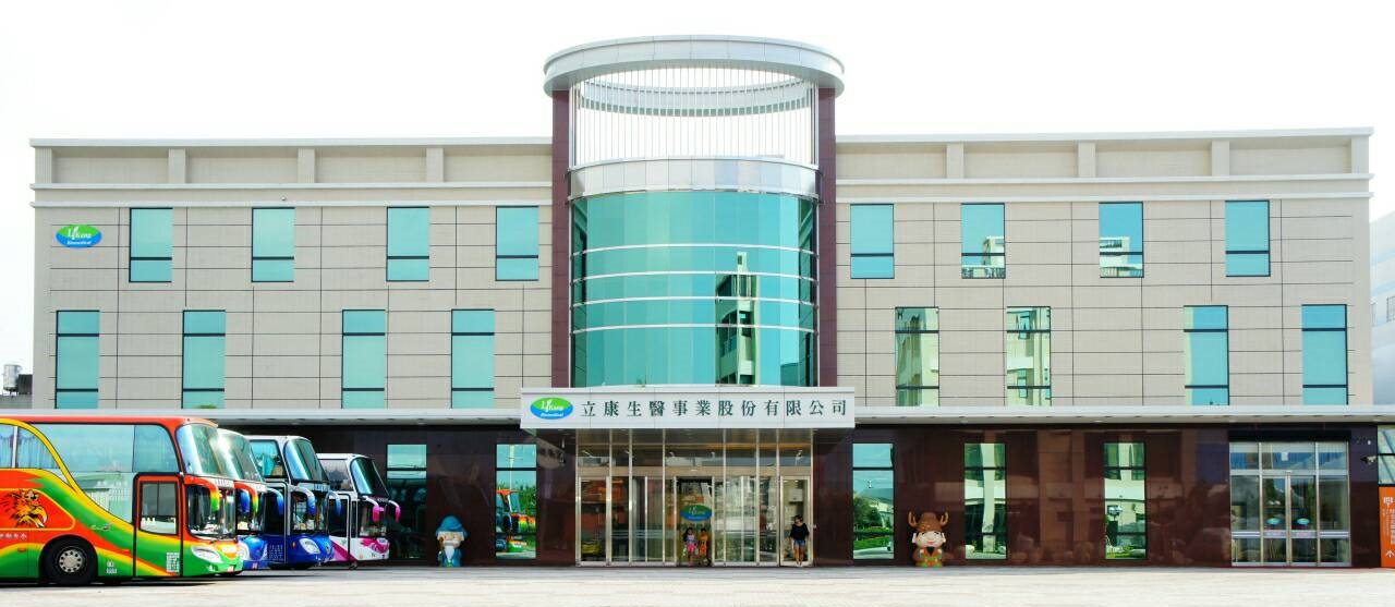 立康健康養生觀光工廠外觀,前方有遊覽車停放