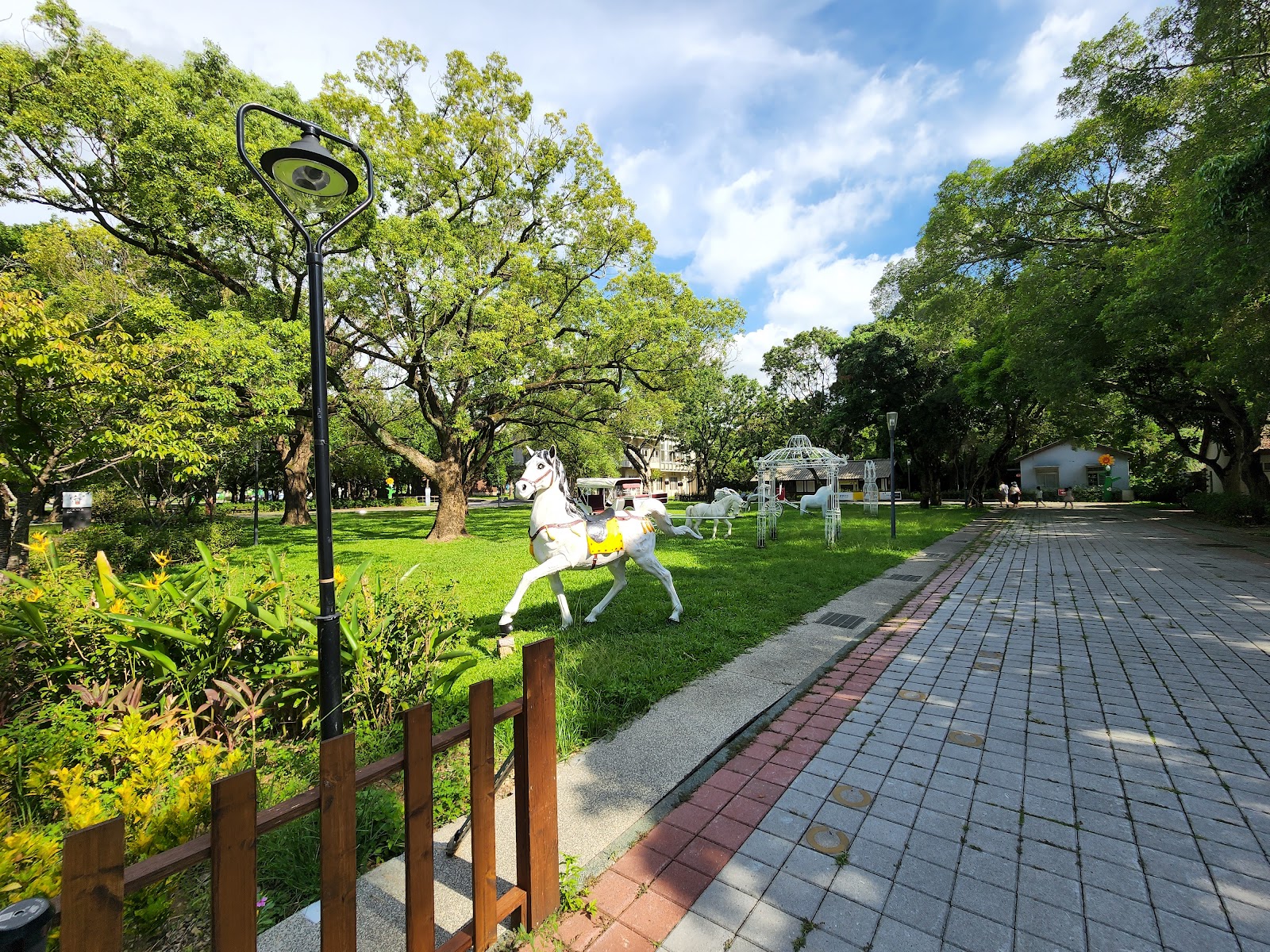 后里馬場園區步道旁白色馬雕塑，綠色草地背景