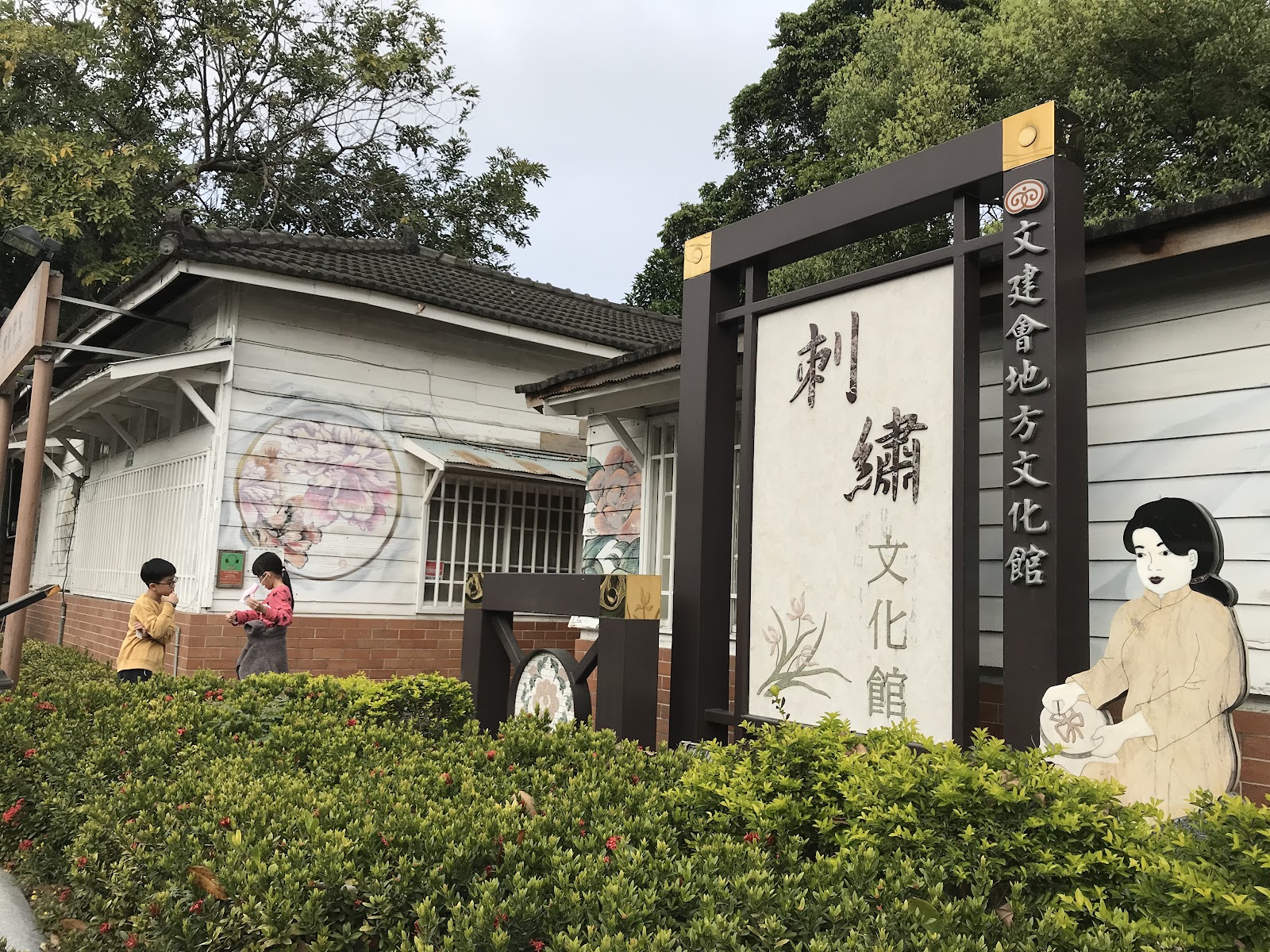 朴子市刺繡文化館外觀大招牌,家庭遊客在入口前留影