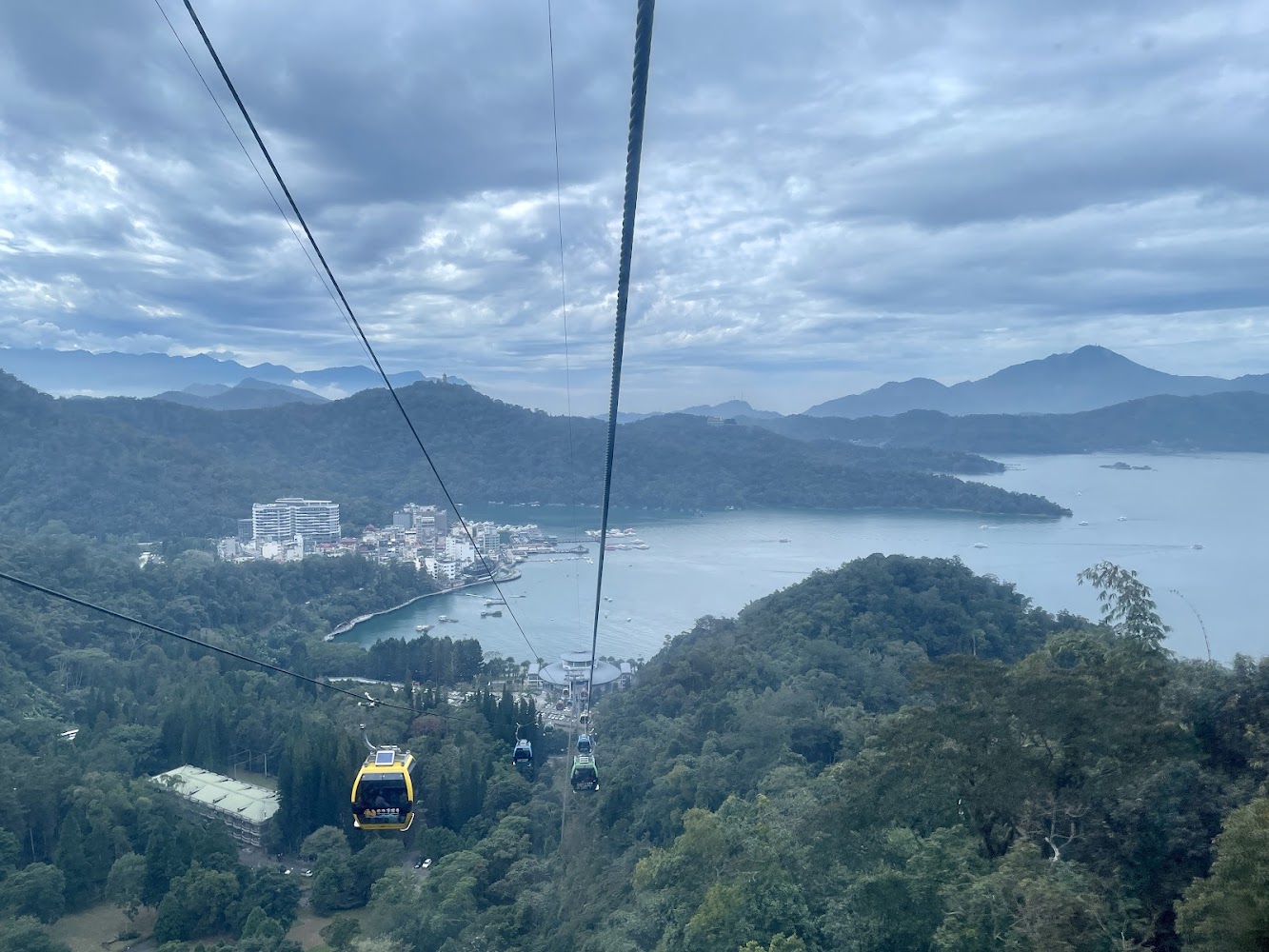 湖泊山林景色與纜車穿越樹林建築群和船隻