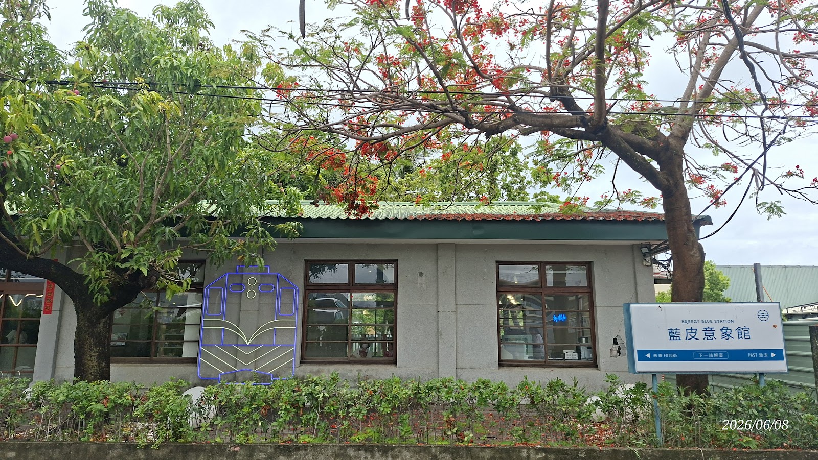 屏東枋寮藍皮意象館外觀,前方鳳凰木盛開橙紅色花朵