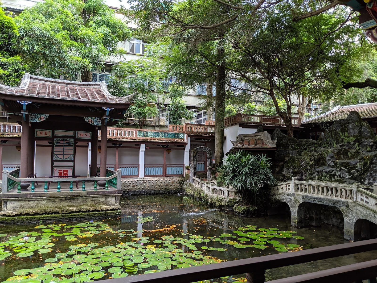 來青閣水榭與荷花池，白色石拱橋，荷葉漂浮，傳統中式建築群環繞