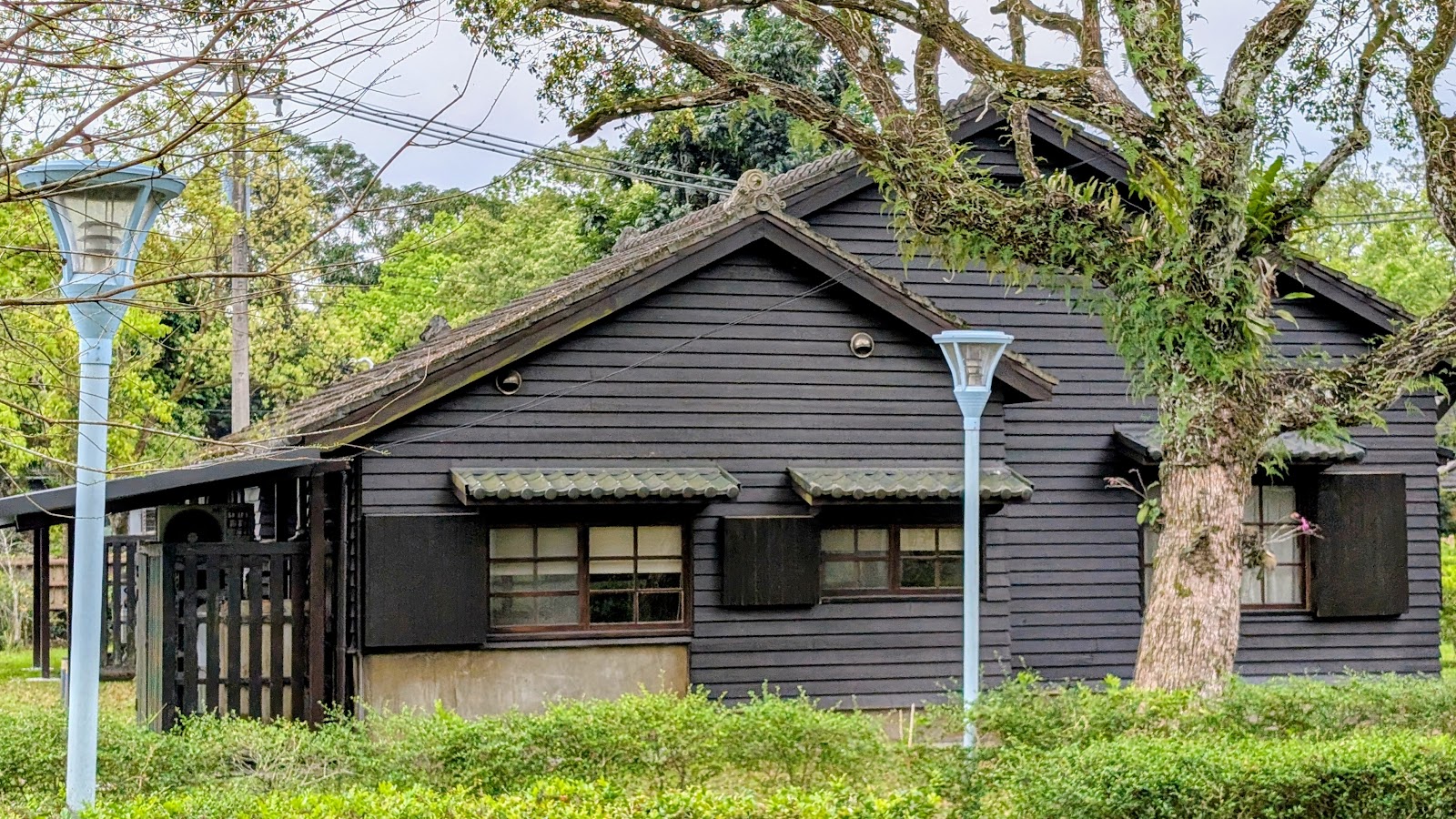 花蓮觀光糖廠黑色日式木造宿舍，兩側有路燈與大樹圍繞