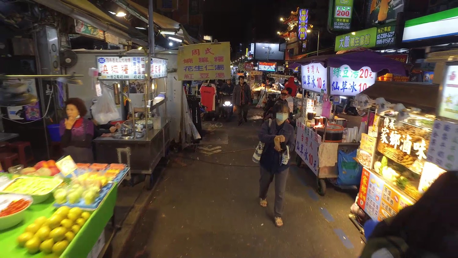 艋舺夜市水果與甜品攤，人群來往熱鬧