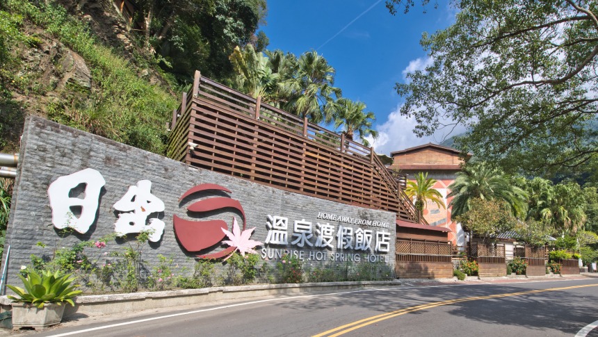 日出溫泉渡假飯店招牌與藍天樹景