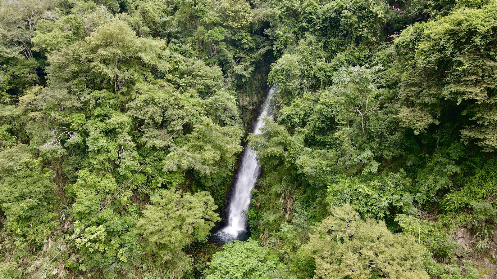清泉瀑布鳥瞰俯視，白色瀑布穿越翠綠山林，五峰清泉部落