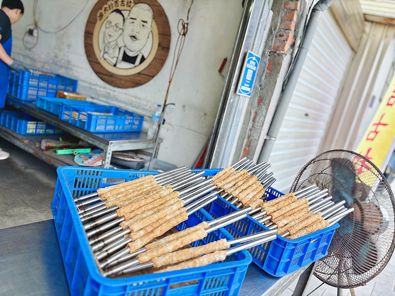 藍色塑膠籃中放著串著食物的棒子