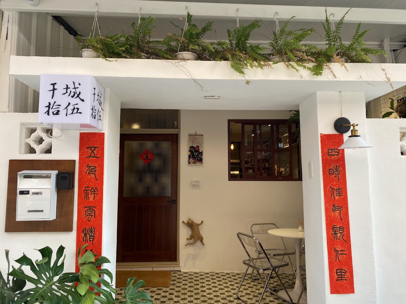 干城拾伍咖啡廳入口有白色牆面與綠色植栽,氛圍溫馨
