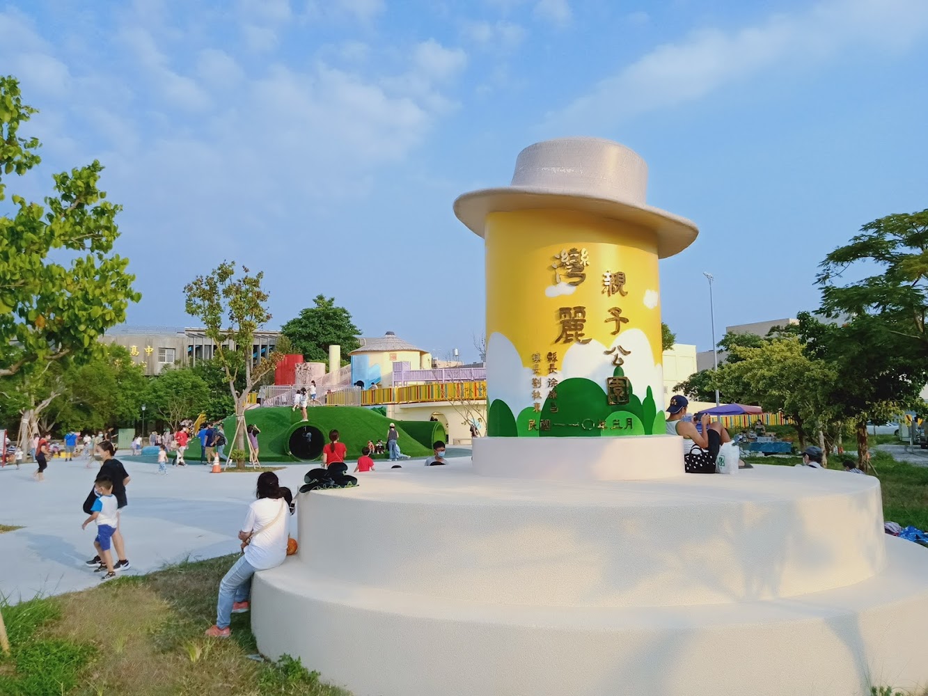 公園入口大型帽子造型標誌與遊客。