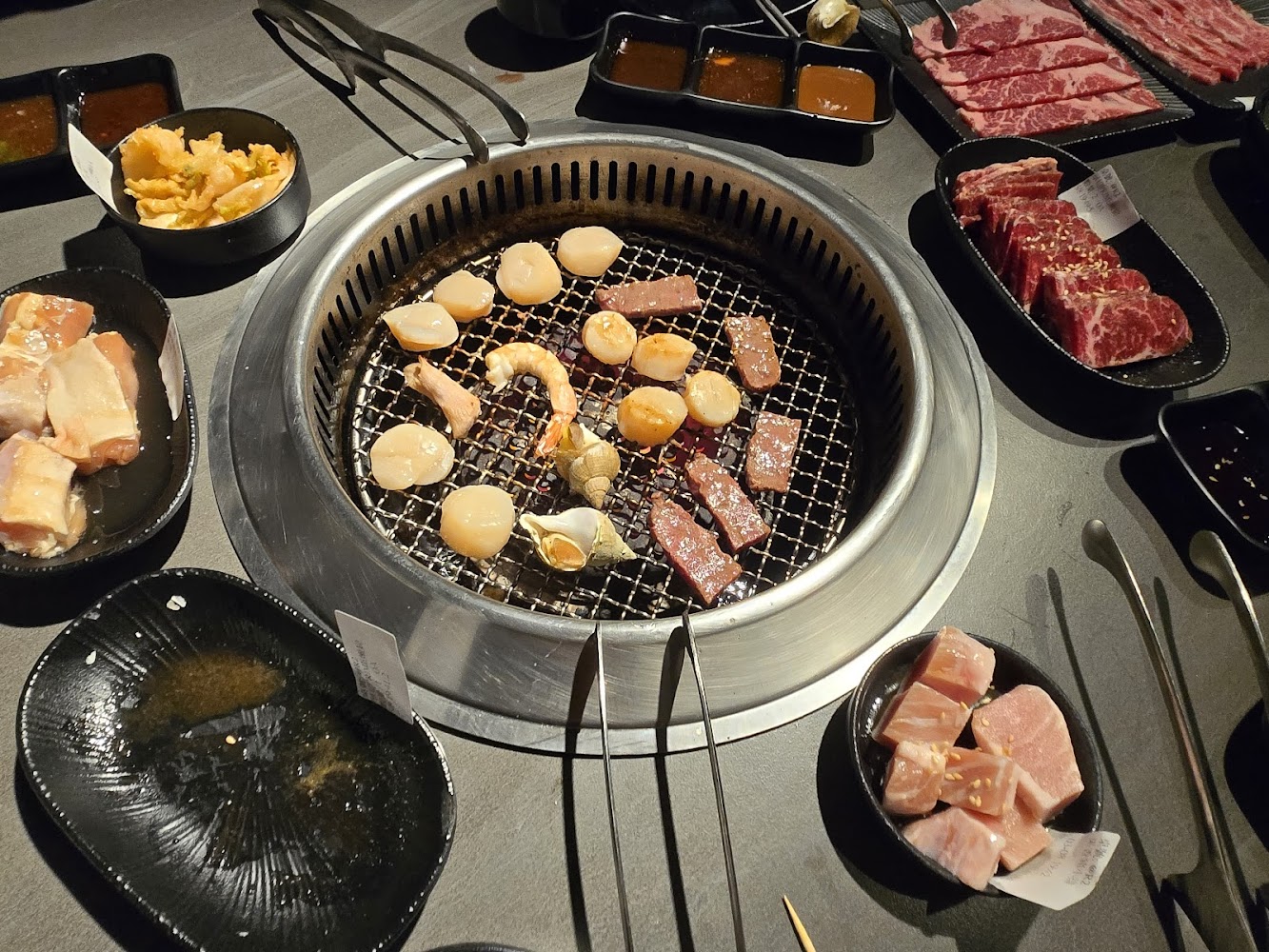 吃肉肉燒肉專門店中壢店燒烤桌面有干貝蝦子與多種肉品