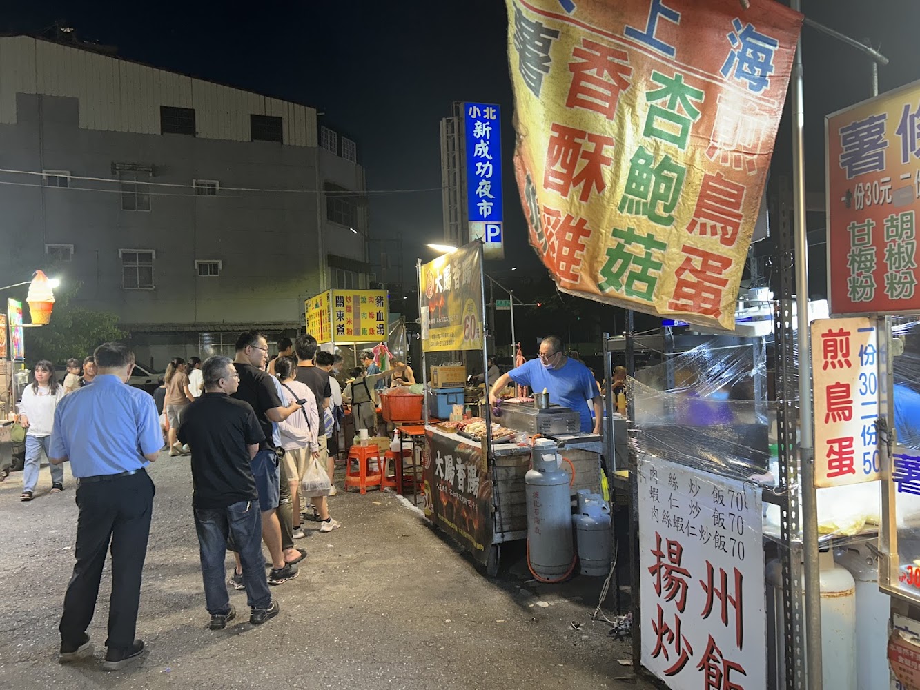 小北新成功夜市熱食攤位與排隊人潮,燈光明亮。