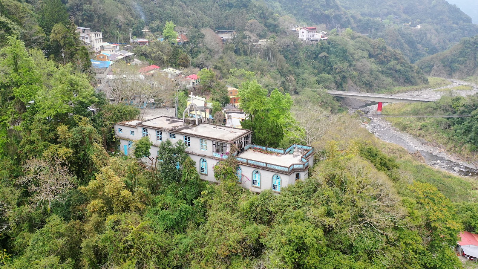 清泉天主堂空拍鳥瞰，白色教堂十字架，溪流環繞山林，新竹五峰