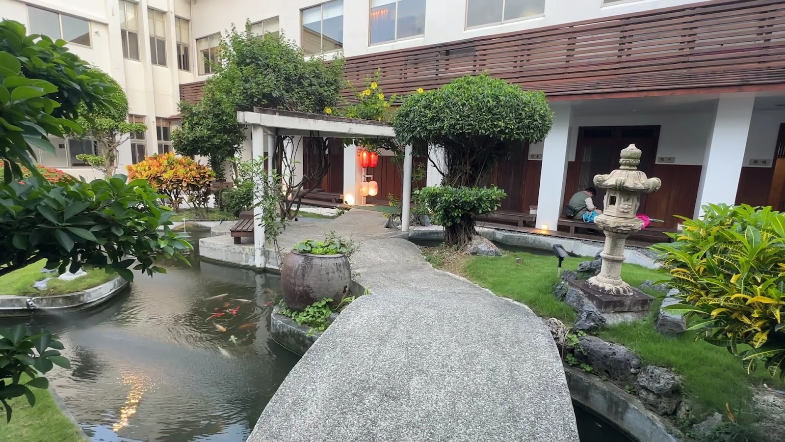 四重溪清泉日式溫泉館白天庭院，石橋跨越錦鯉池，石燈籠紅燈籠