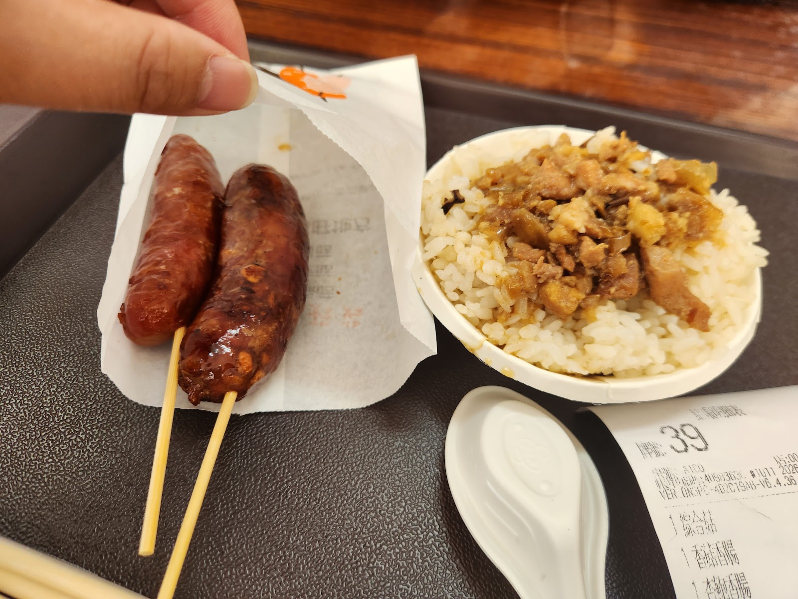 新社百菇莊香菇香腸串與一碗魯肉飯，放在黑色托盤上