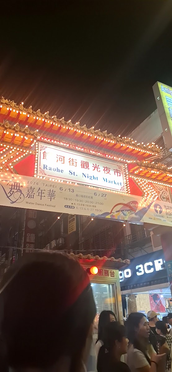 台北饒河街觀光夜市入口夜景燈火通明人潮湧入