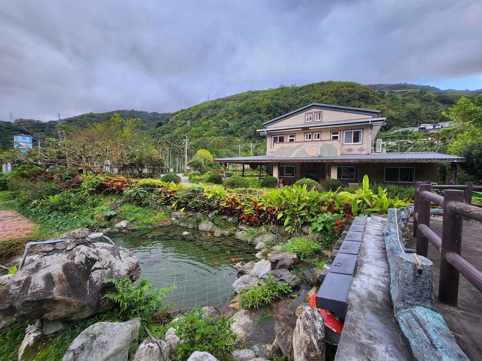慕谷慕魚旅遊諮詢中心附近日式建築，庭園水池與翠綠山丘