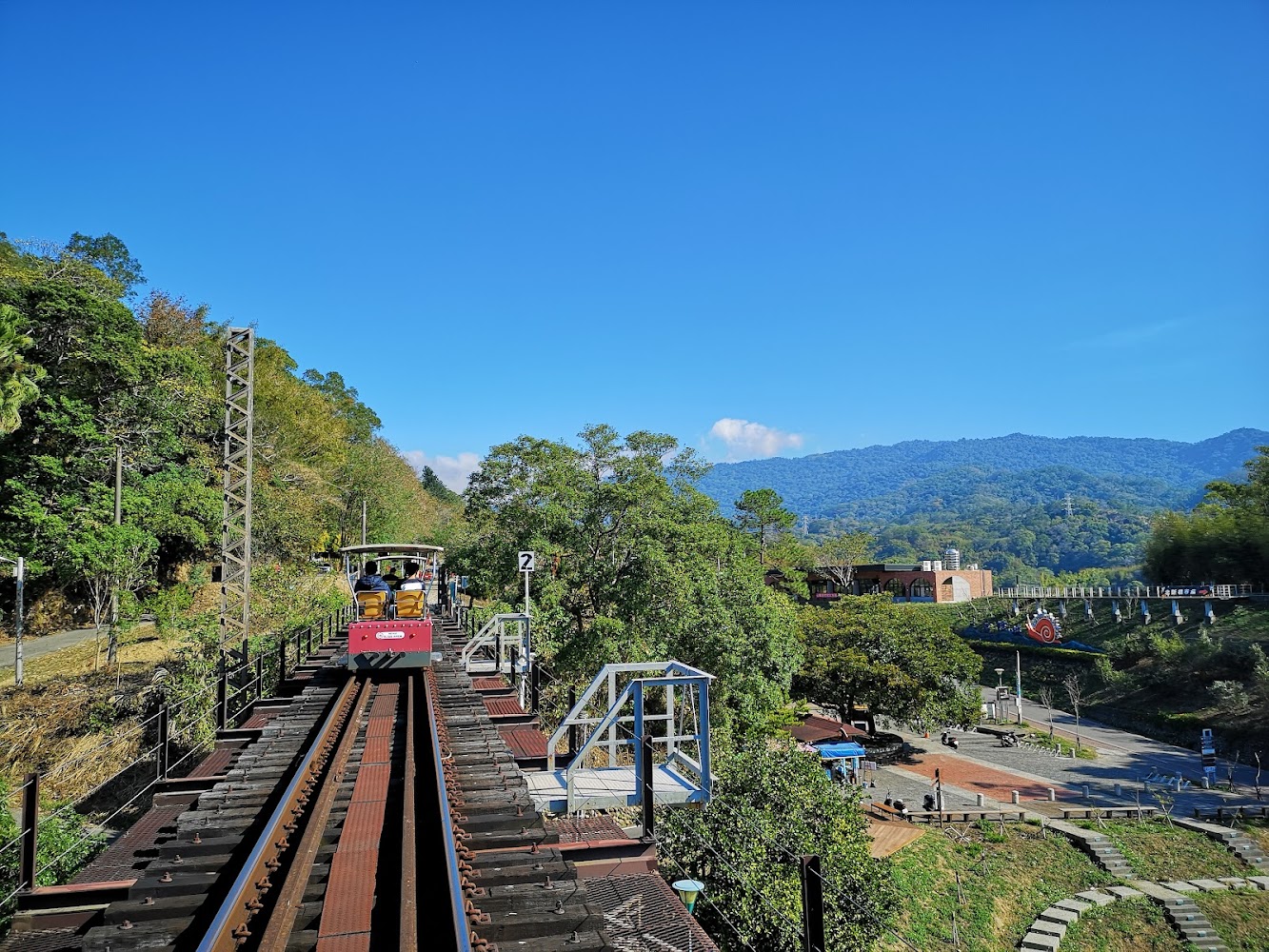 紅色小火車行駛於軌道山景中