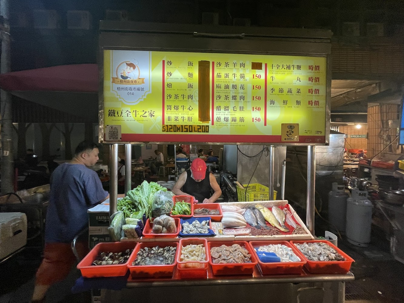 梧州街夜市海鮮攤位，陳列魚蝦螺貝等食材