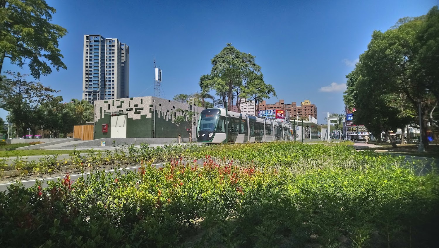 高雄輕軌列車行駛於綠化都市道路旁