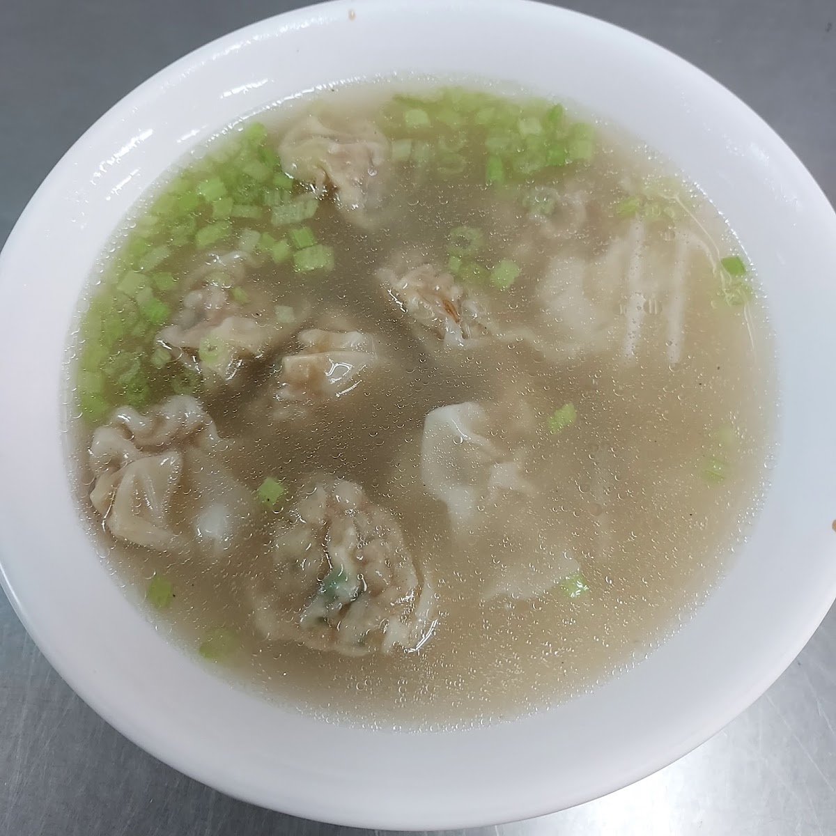 里港扁食湯俯拍，白碗盛飽滿扁食加蔥花