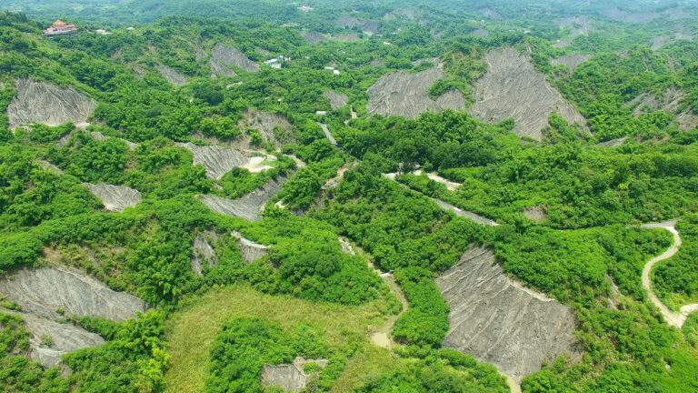 台南龍崎牛埔惡地空拍俯瞰，灰白泥岩地形與翠綠植被交錯分布的壯觀景象