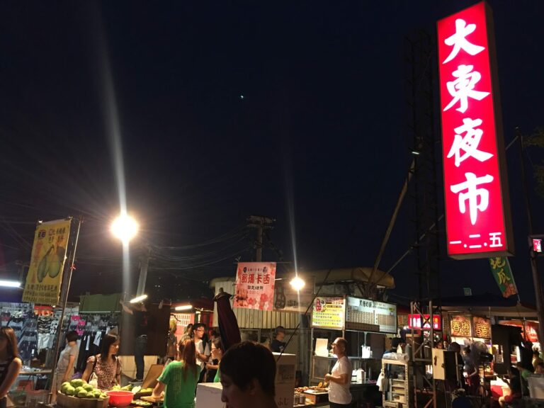 台南大東夜市入口夜晚，紅色大東夜市招牌燈光明亮人潮聚集