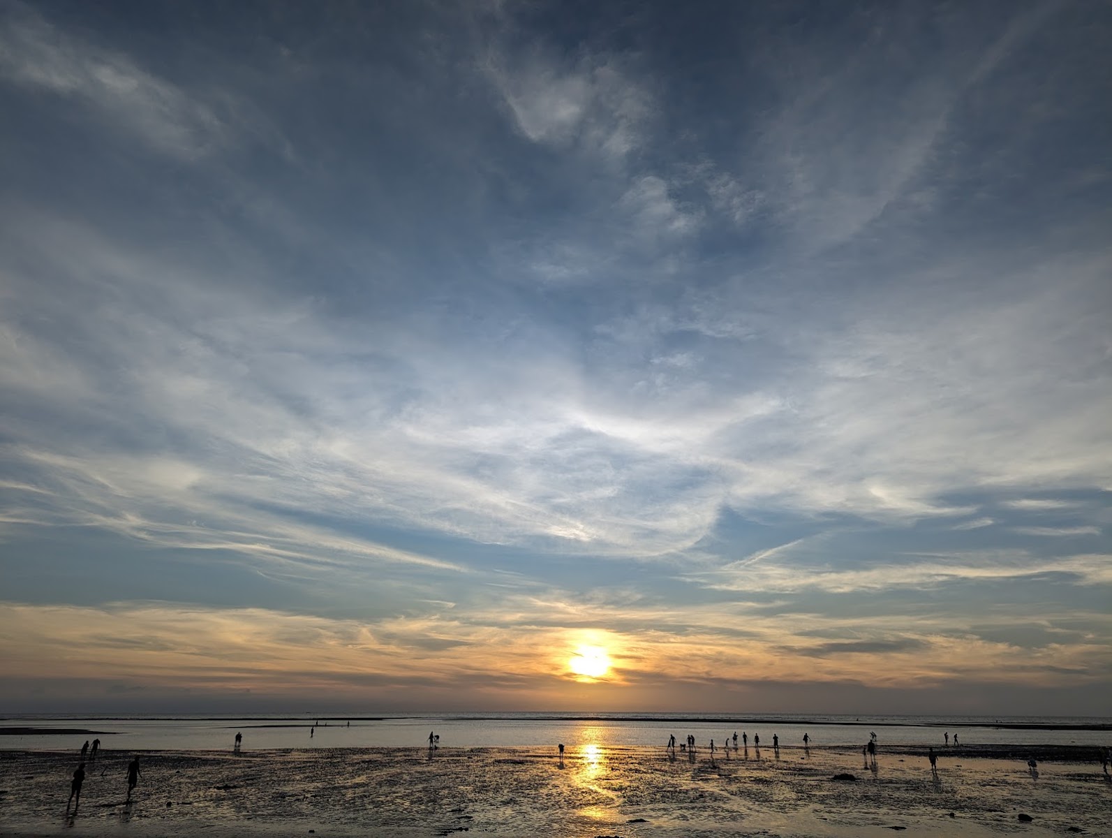 台中大安海水浴場夕陽壯觀景色，海灘人群剪影與橙紅天空