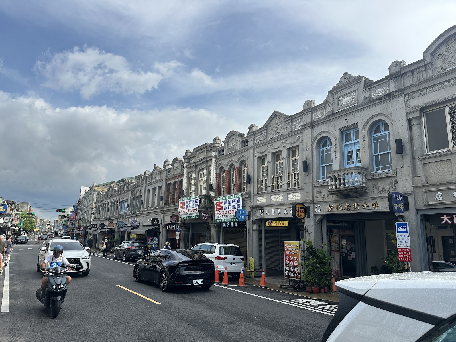 台南新化老街日式巴洛克街屋立面，藍天白雲，機車穿梭