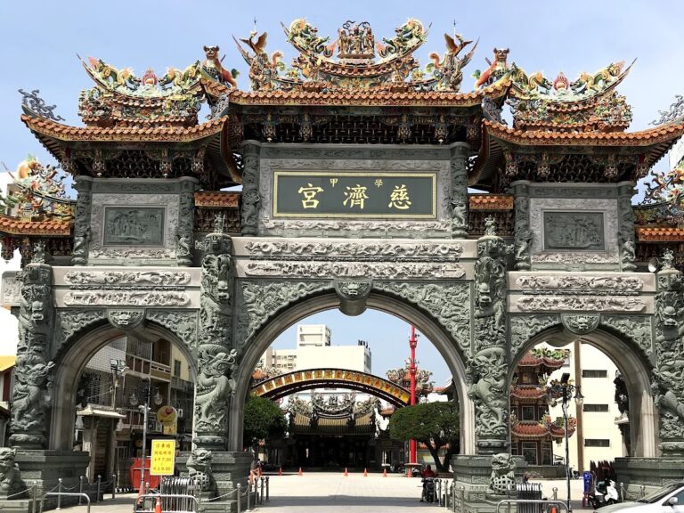 台南學甲慈濟宮大牌坊正面，石雕精緻背景藍天
