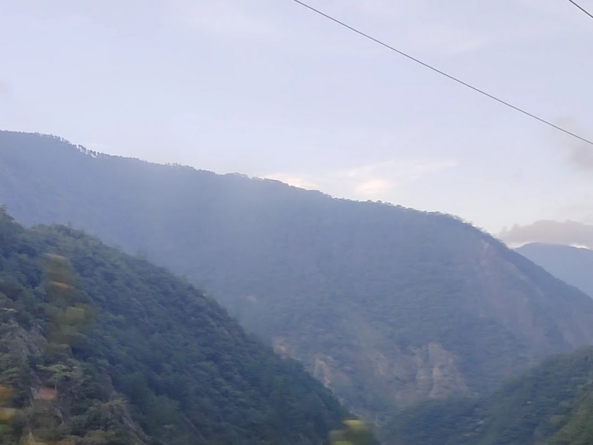 德基水庫大壩溢洪景象，白色水流從壩底傾瀉進入峽谷