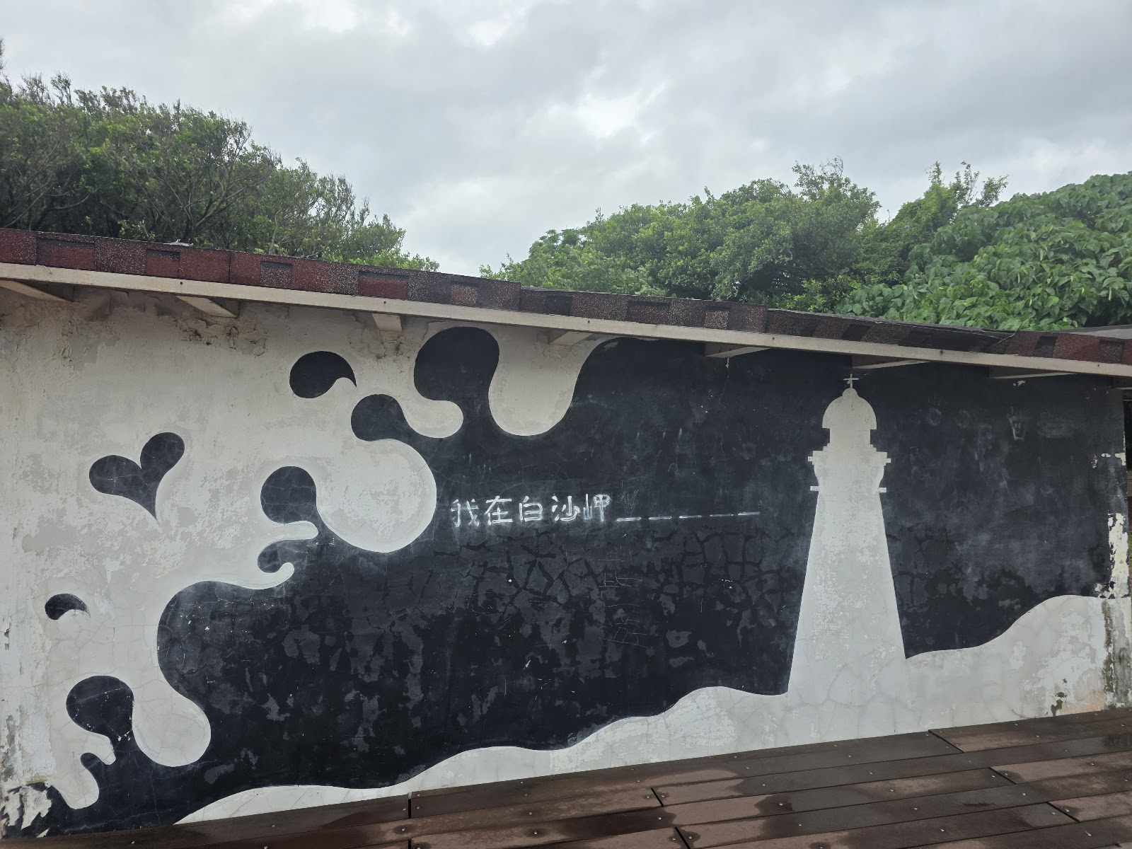 白沙岬燈塔彩繪牆,黑白手繪我在白沙岬字樣,搭配燈塔海浪圖案打卡景點