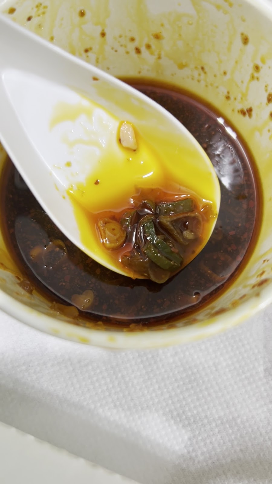 鼎泰豐小籠包沾醬特寫,磁碗內蔥薑醋醬搭配白瓷湯匙