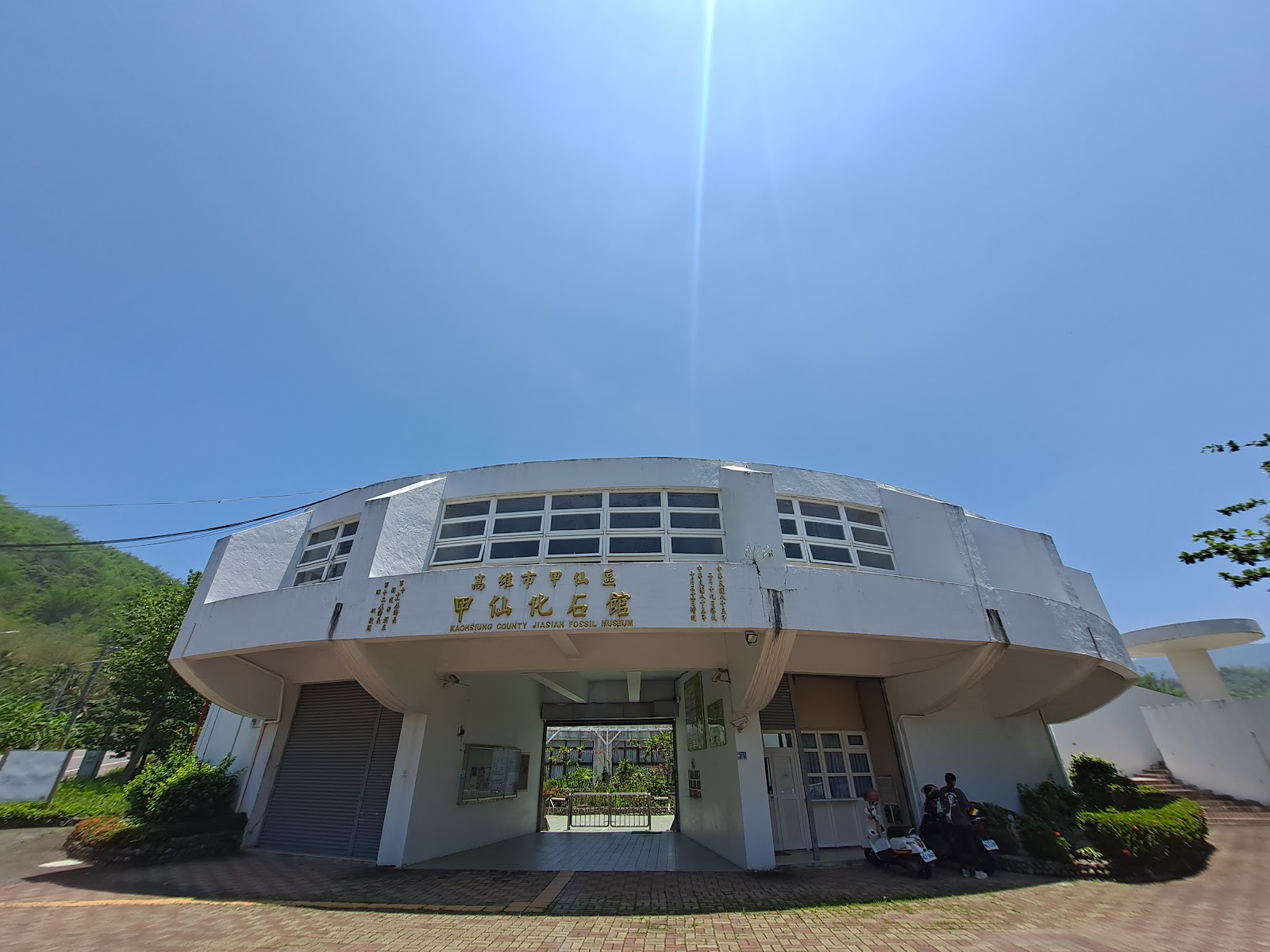 高雄甲仙化石館白色橢圓形建築正面外觀金色招牌藍天