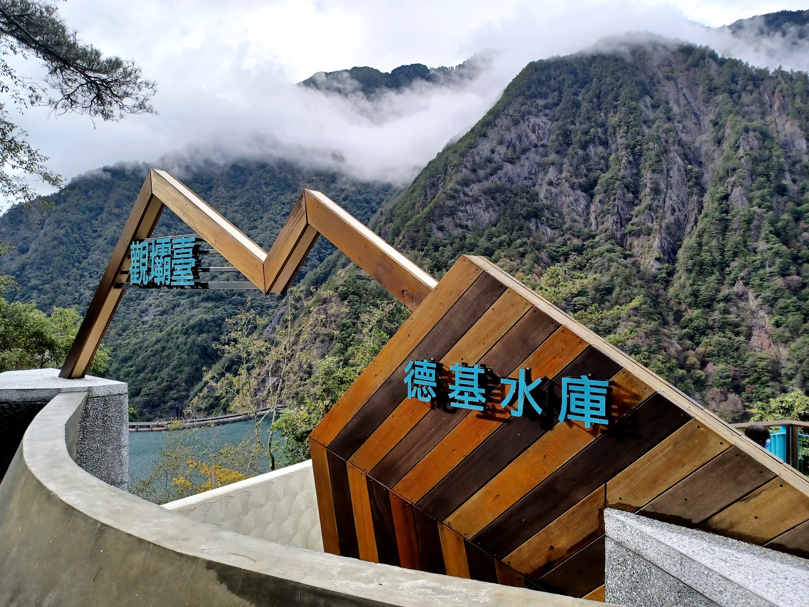 德基水庫觀壩臺木構景觀裝置，藍字德基水庫標誌與峽谷山景