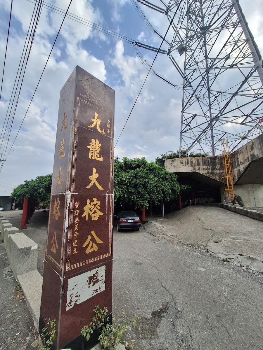 竹塘九龍大榕公入口石碑，背景可見鐵路橋