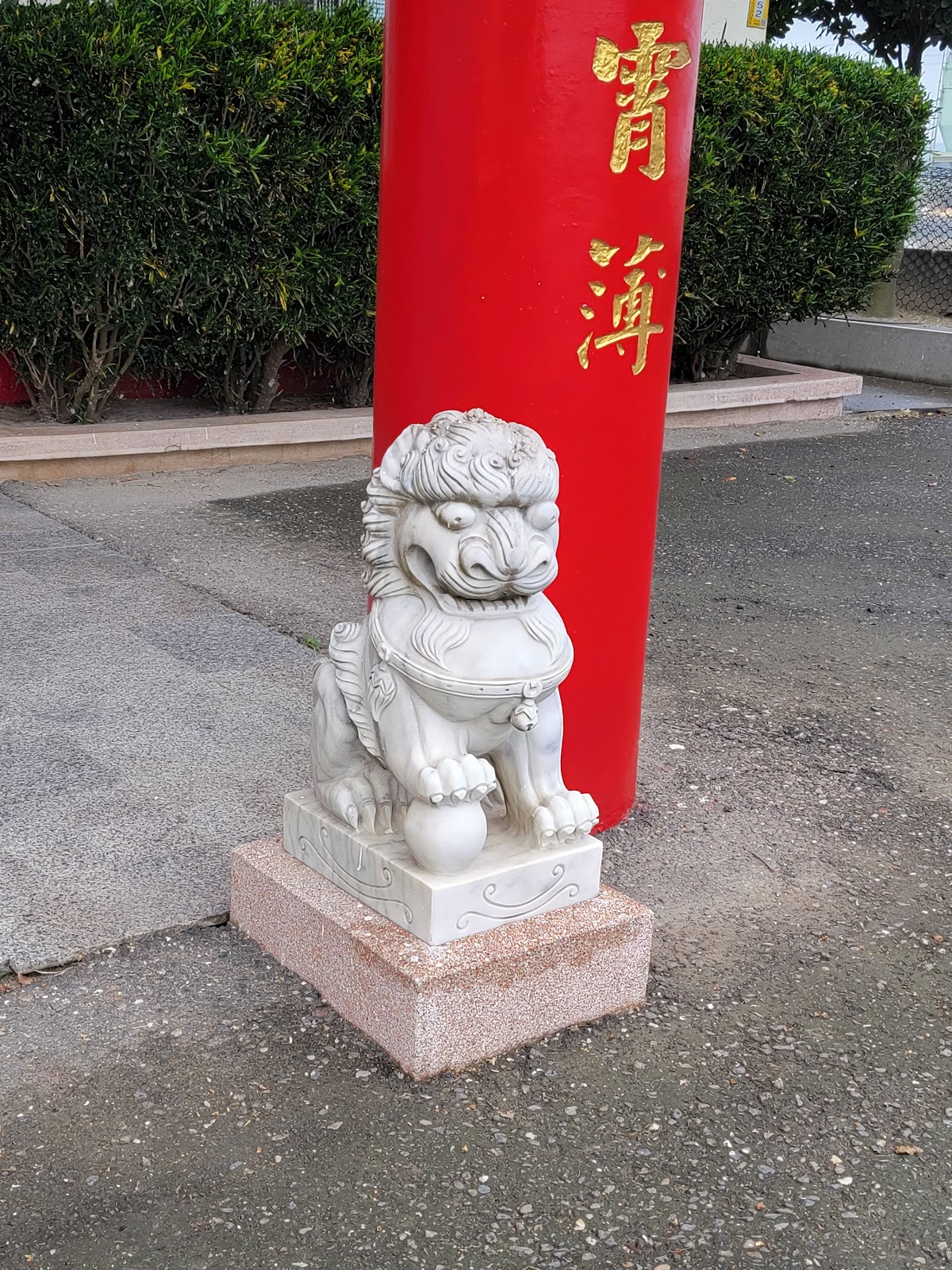 十八將軍祠門口白色石獅特寫，紅柱背景